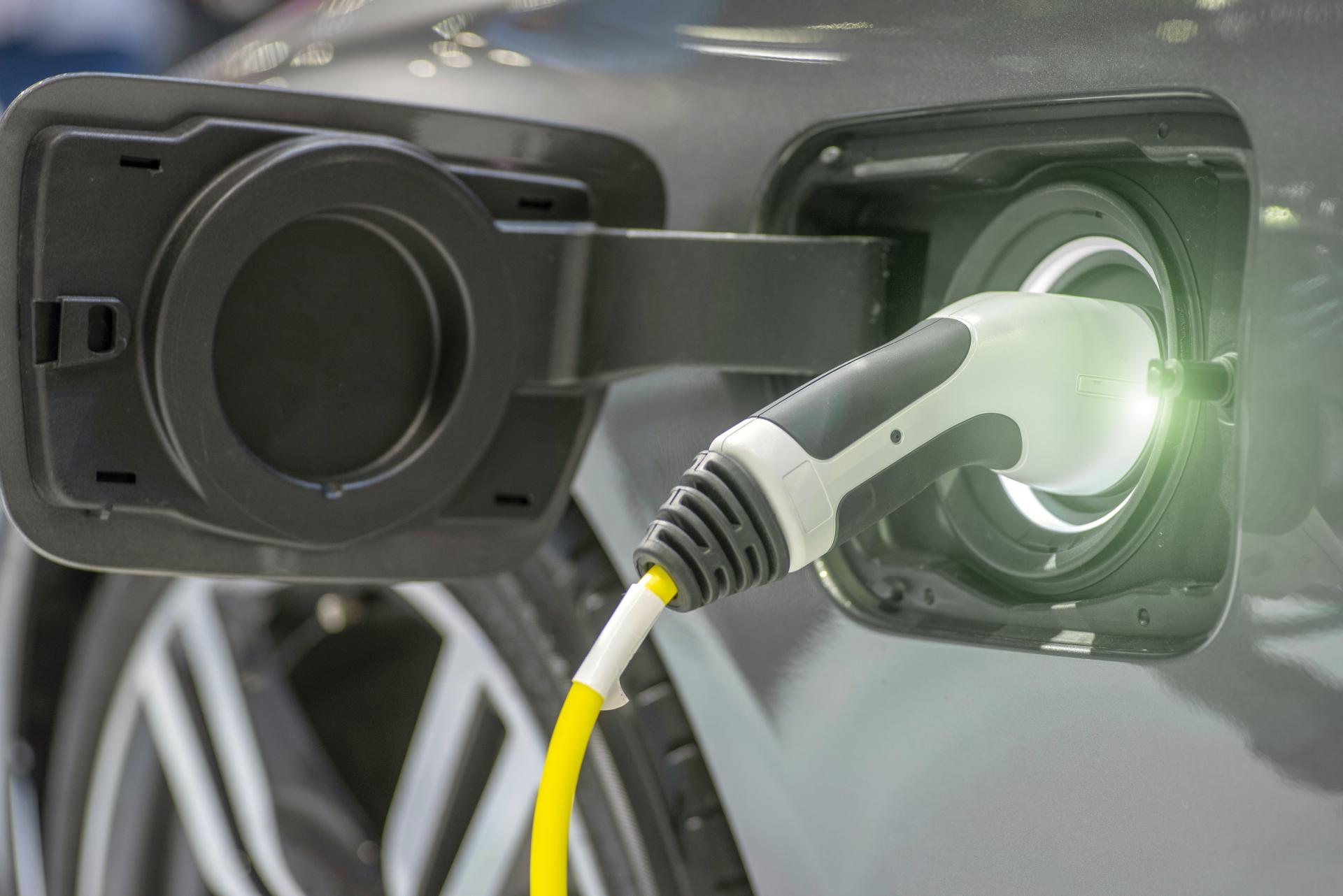 Close up of the electric charging station with power supply plugged into an electric car